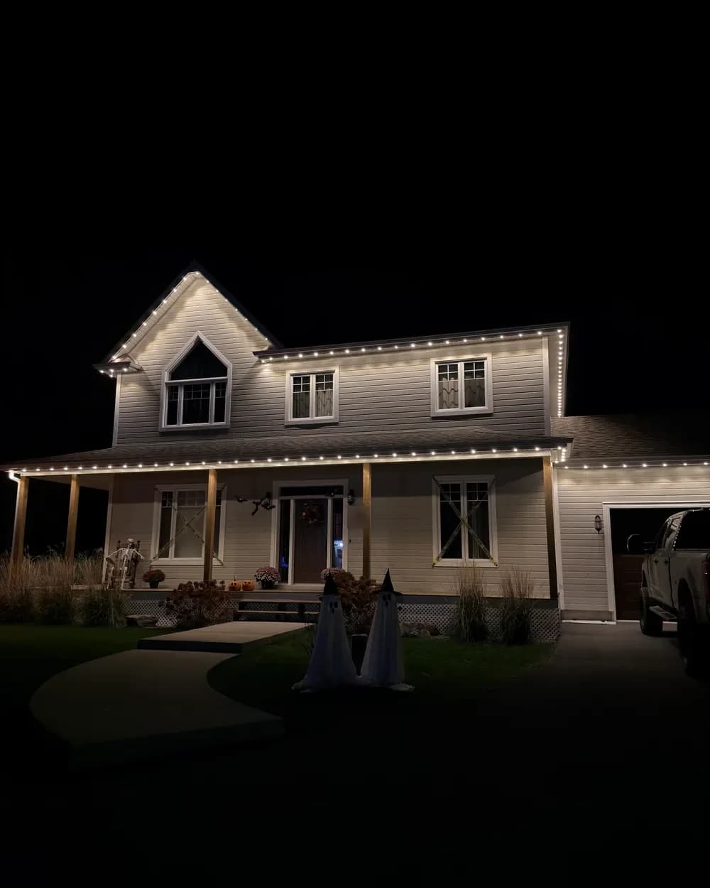 Installation de lumières LED permanentes au Québec : maison à étage avec galerie, blanc chaud