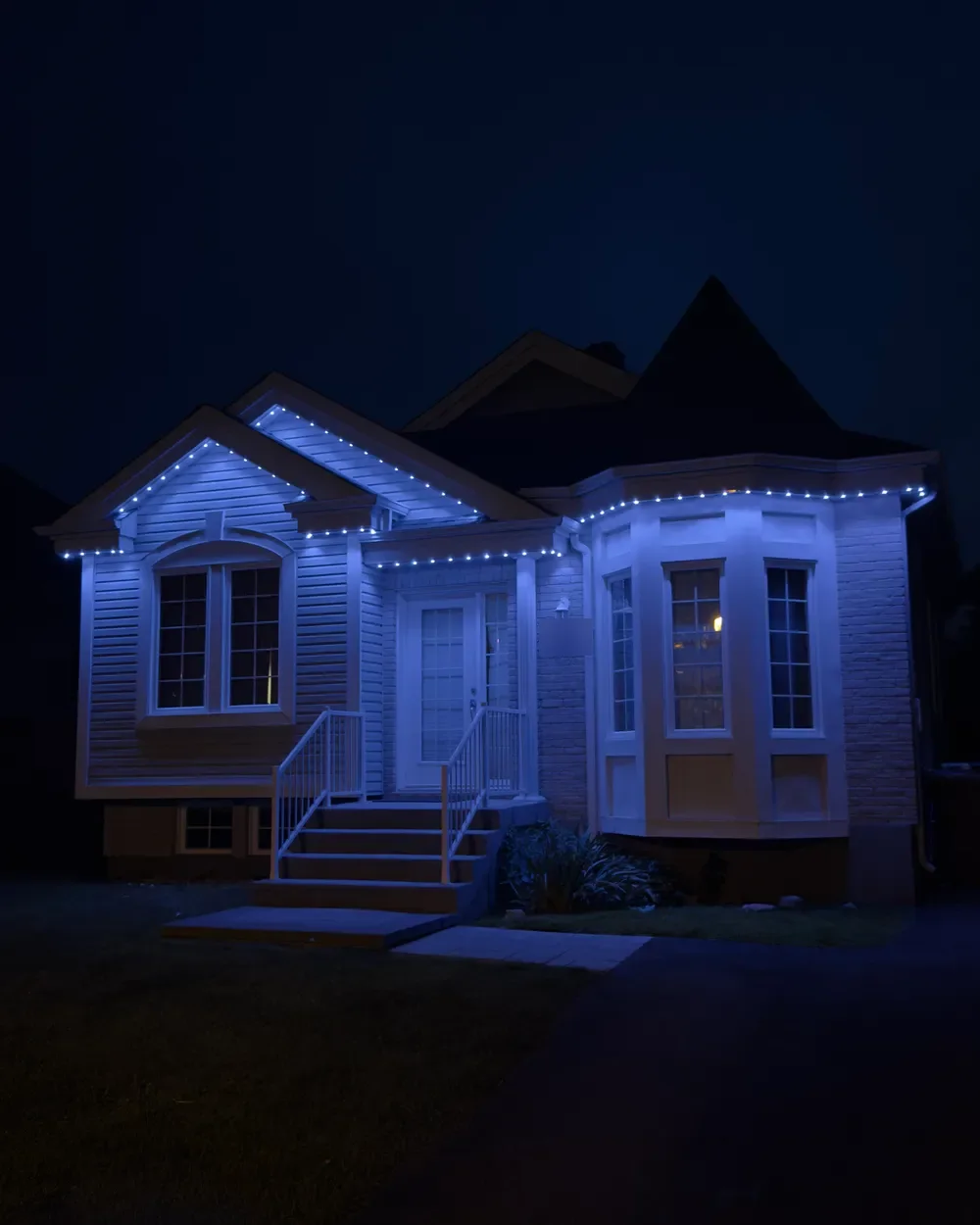 Installation de lumières LED permanentes au Québec : bungalow surélevé, bleu pâle