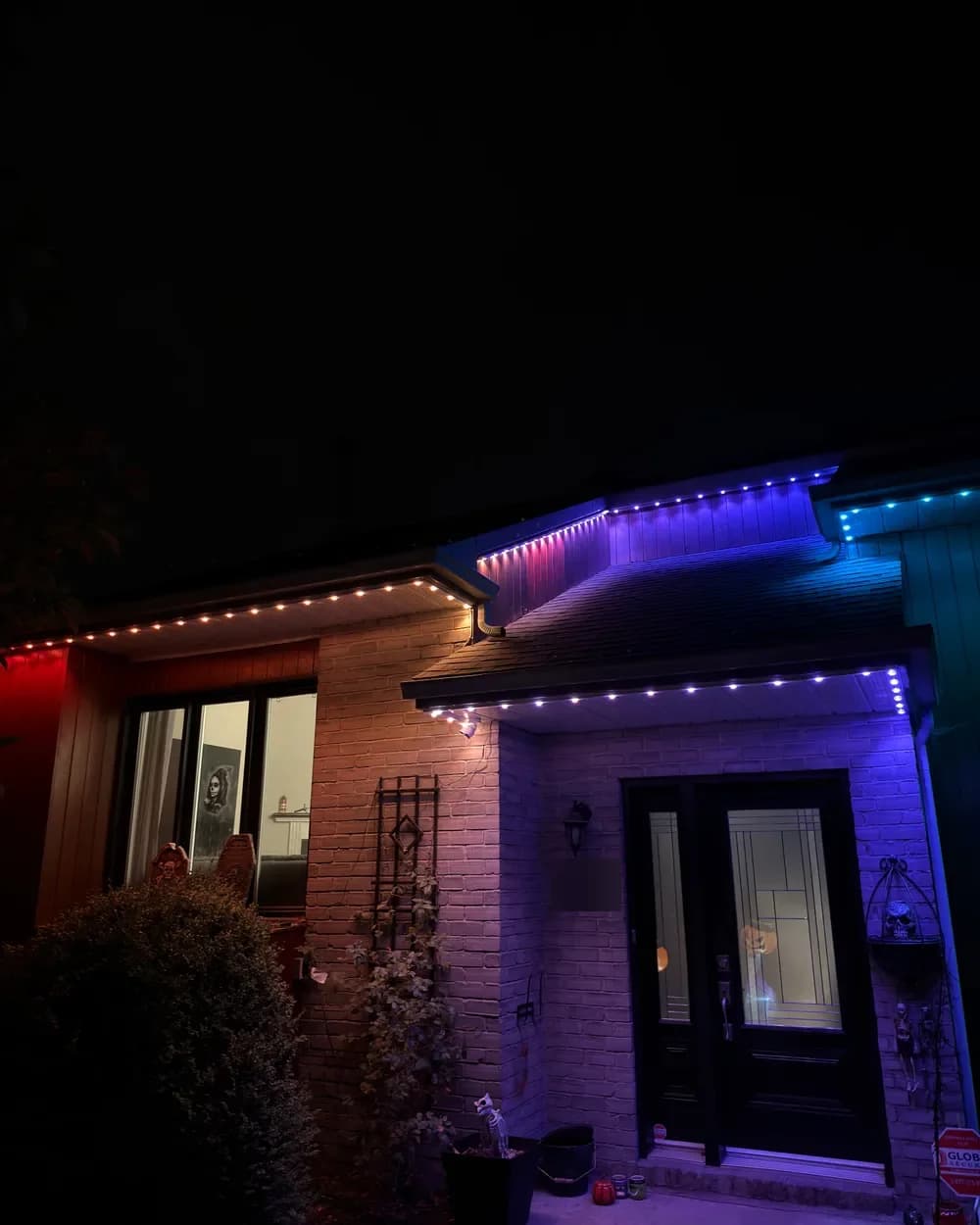 Installation de lumières LED permanentes au Québec : entrée d’une maison de brique, multicolore