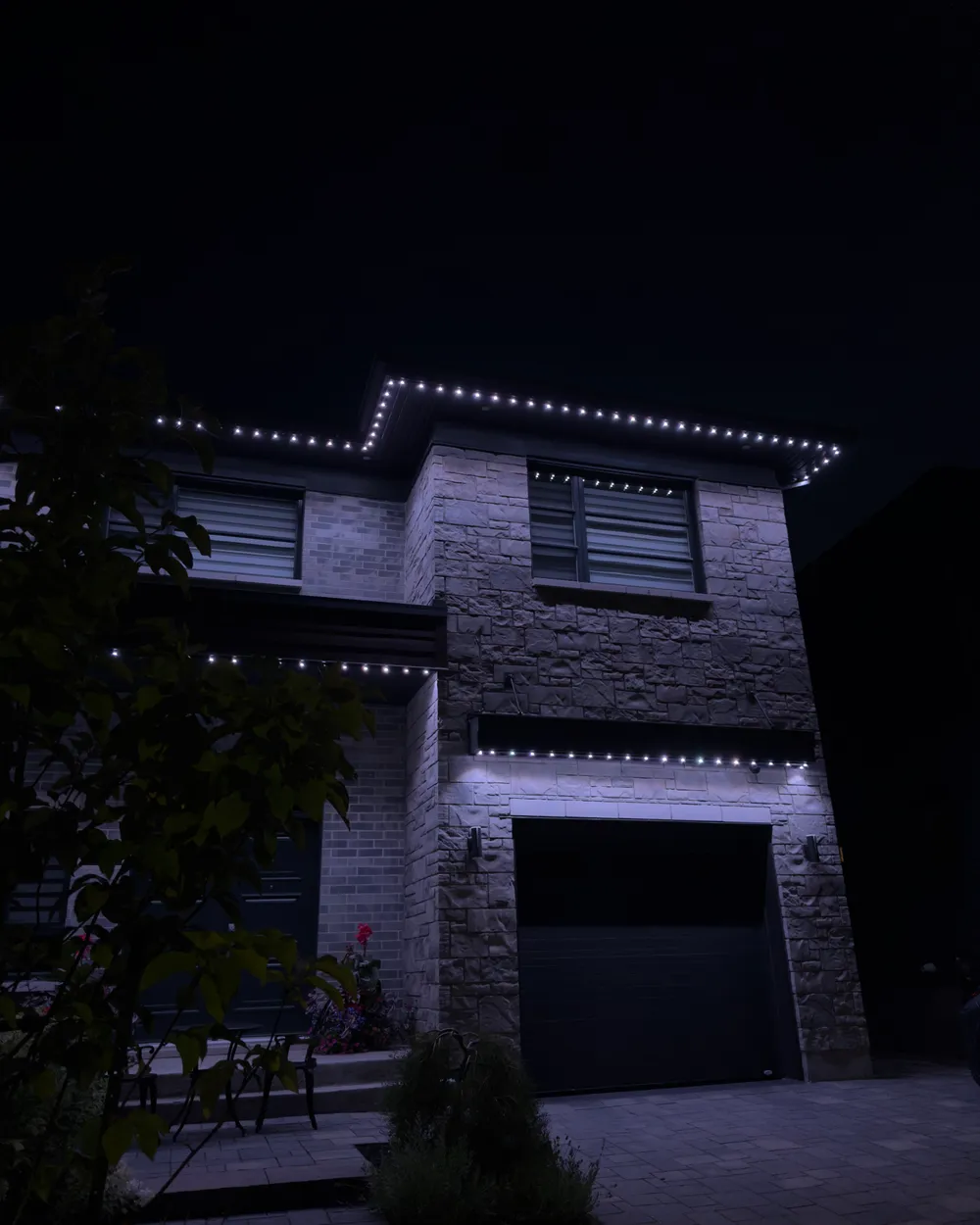Installation de lumières LED permanentes au Québec : maison moderne en pierre, blanc froid