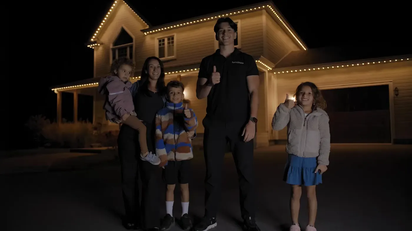 La famille de Charle devant leur maison illuminée