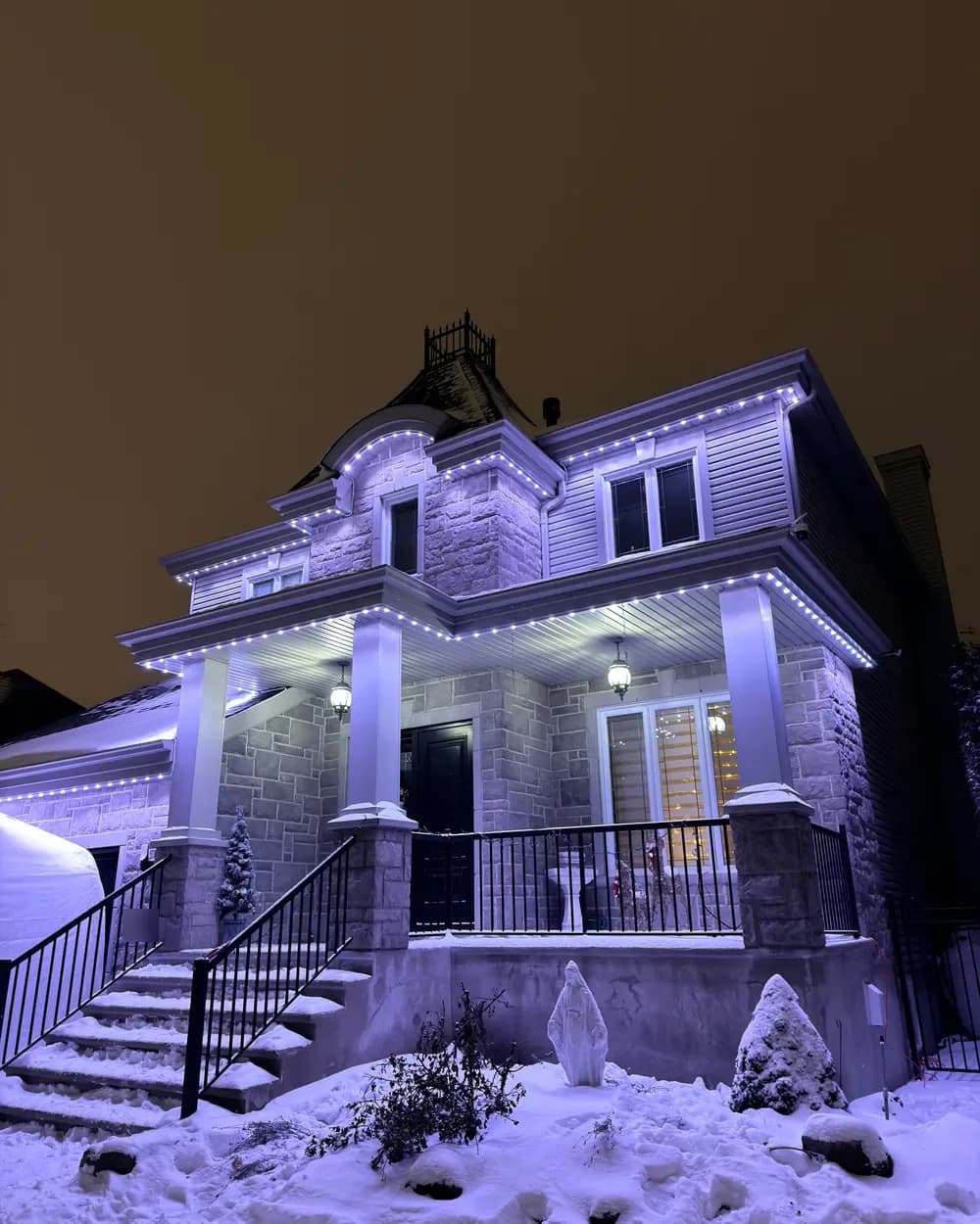 Installation de lumières LED permanentes au Québec : maison de pierre sous la neige, lavande