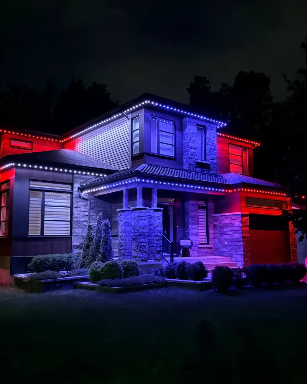 Installation de lumières LED permanentes au Québec : maison en pierre et déclin, rouge et bleu