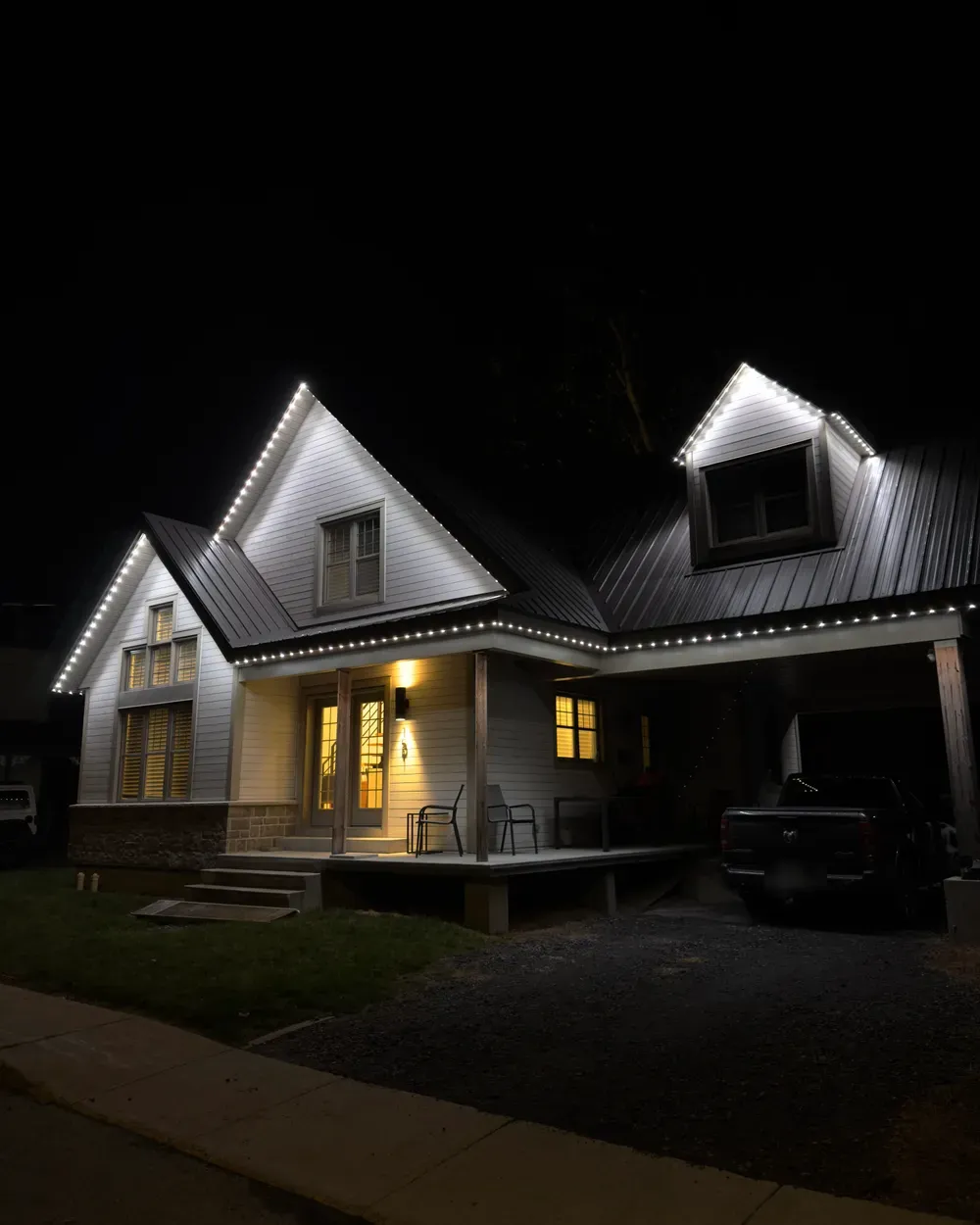 Installation de lumières LED permanentes au Québec : maison à toit de tôle, lumières blanches