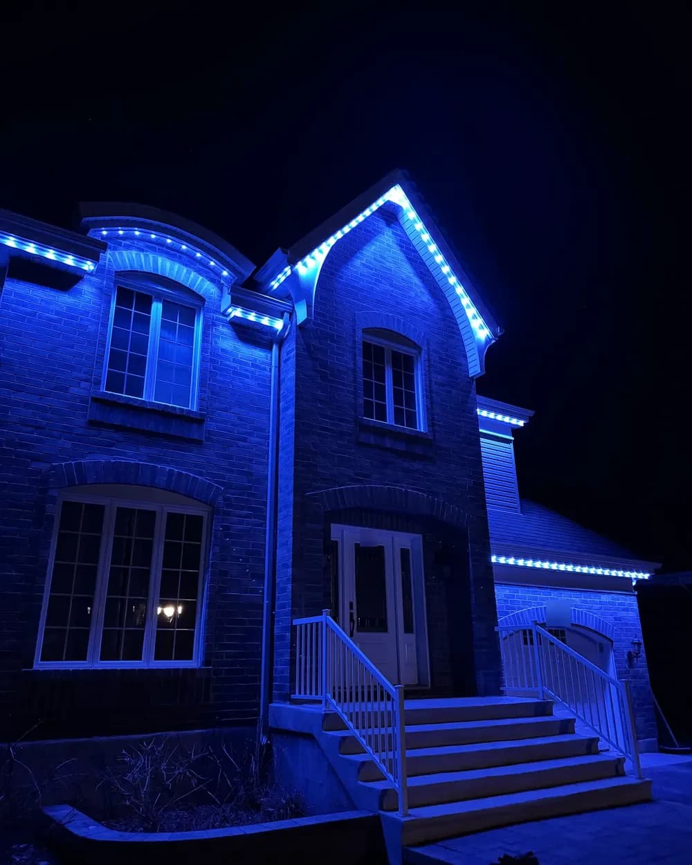 Installation de lumières LED permanentes au Québec : maison de brique à étage, lumières bleues