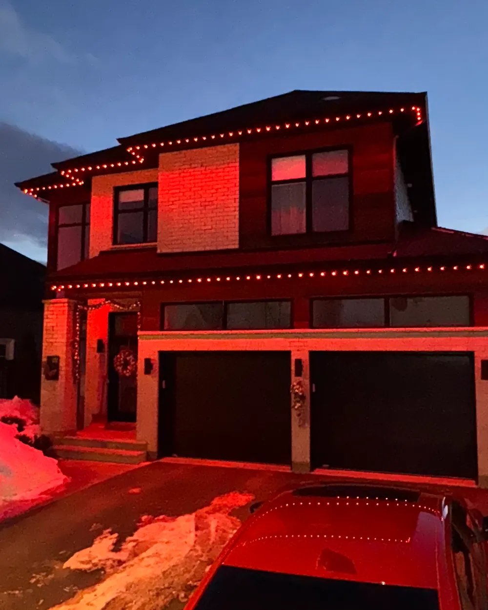Installation de lumières LED permanentes au Québec : maison de brique moderne, lumières rouges